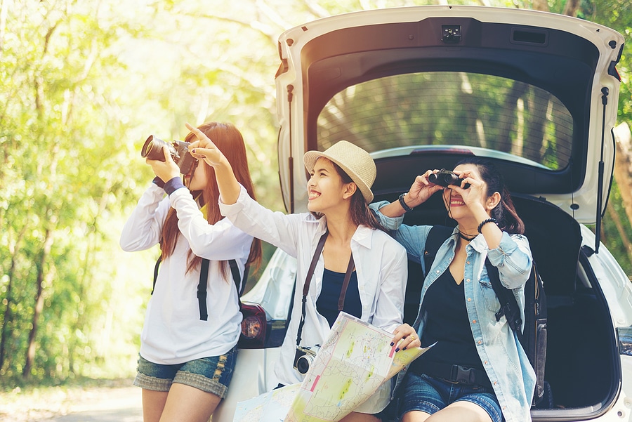 Three women peer at interesting sights from the comfort of their rental vehicle.